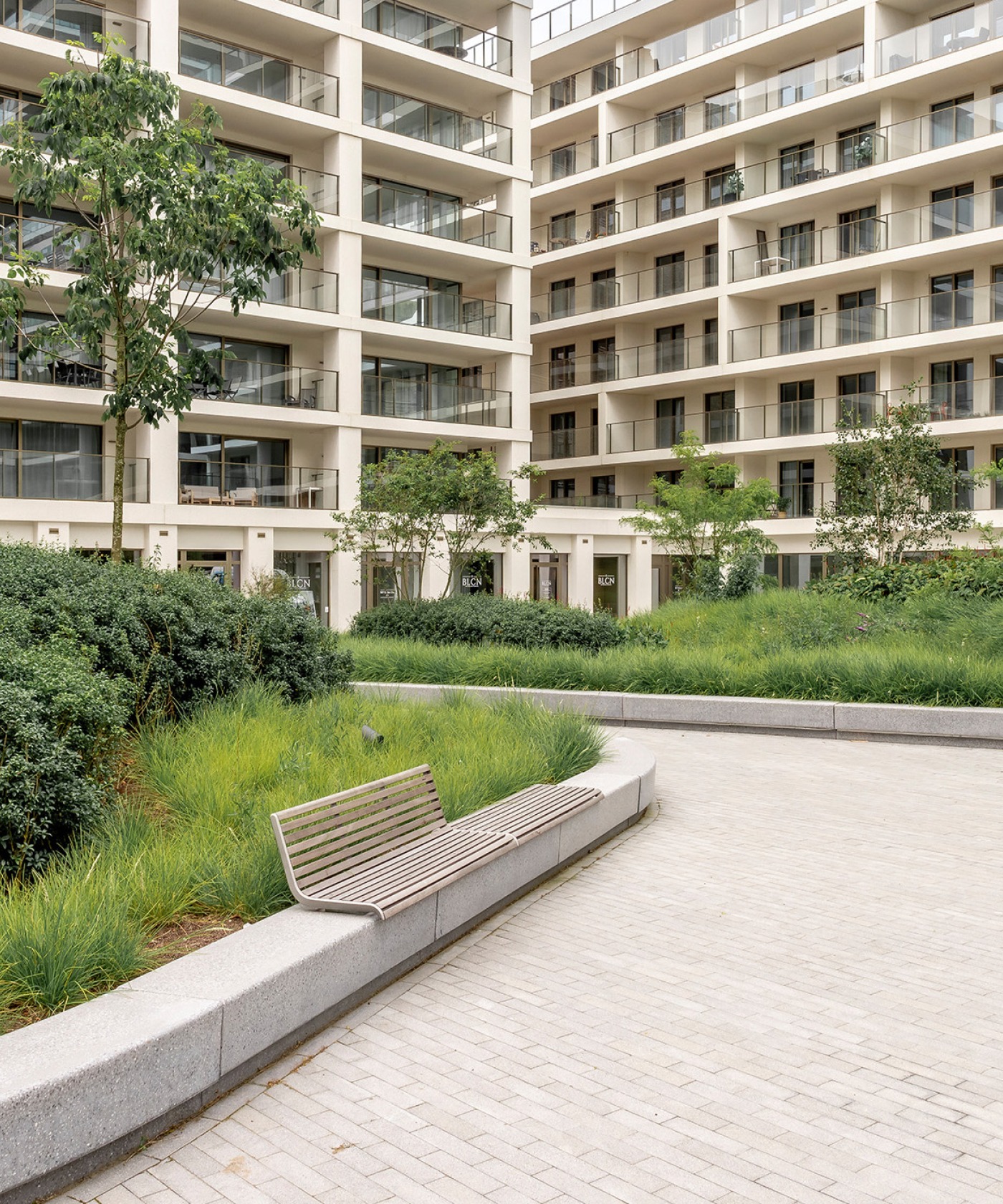 Groen dak bij de Sky Towers in Oostende, omringd door moderne appartementen met zitbanken en gevarieerde beplanting