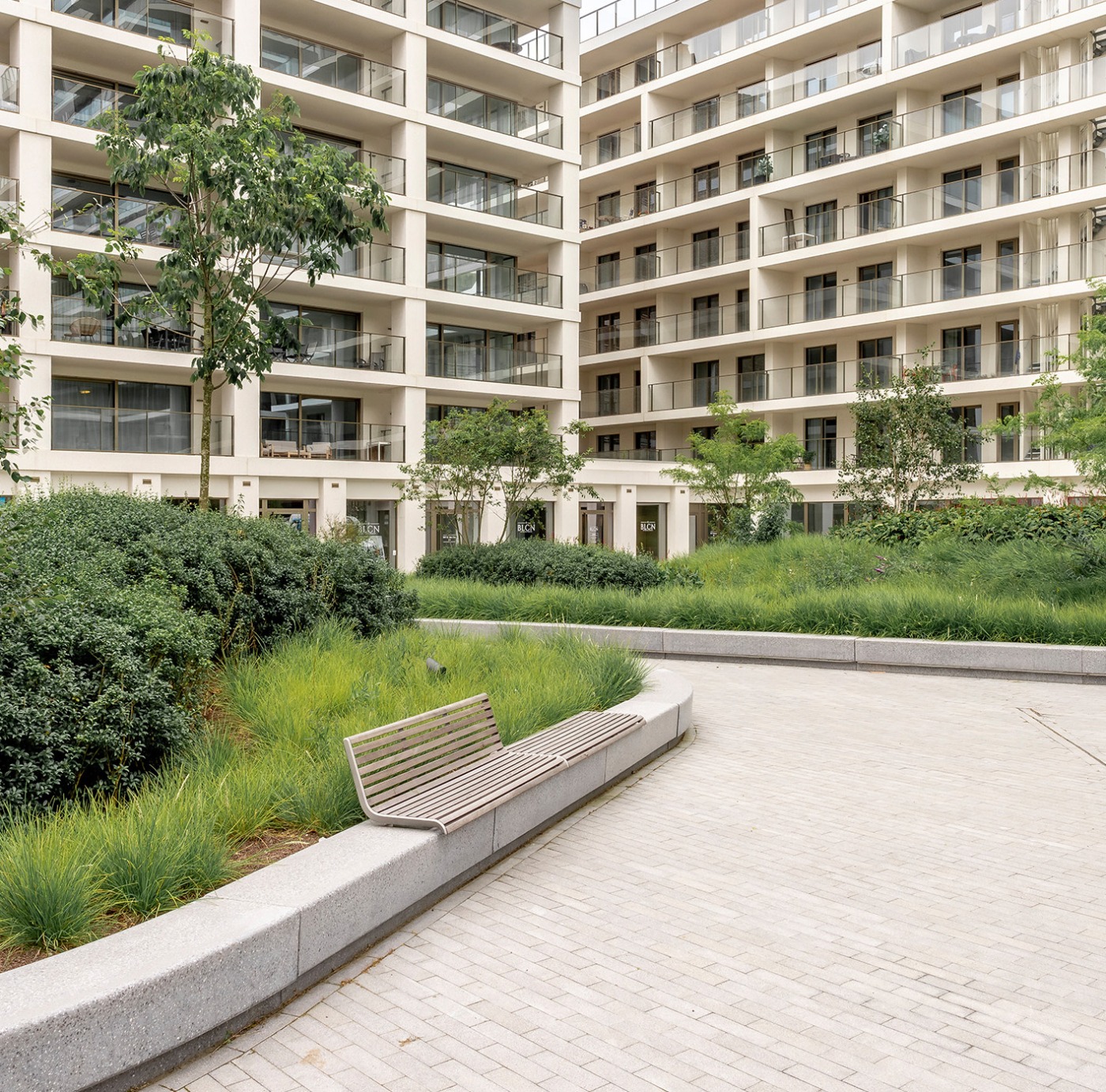 Groen dak bij de Sky Towers in Oostende, omringd door moderne appartementen met zitbanken en gevarieerde beplanting